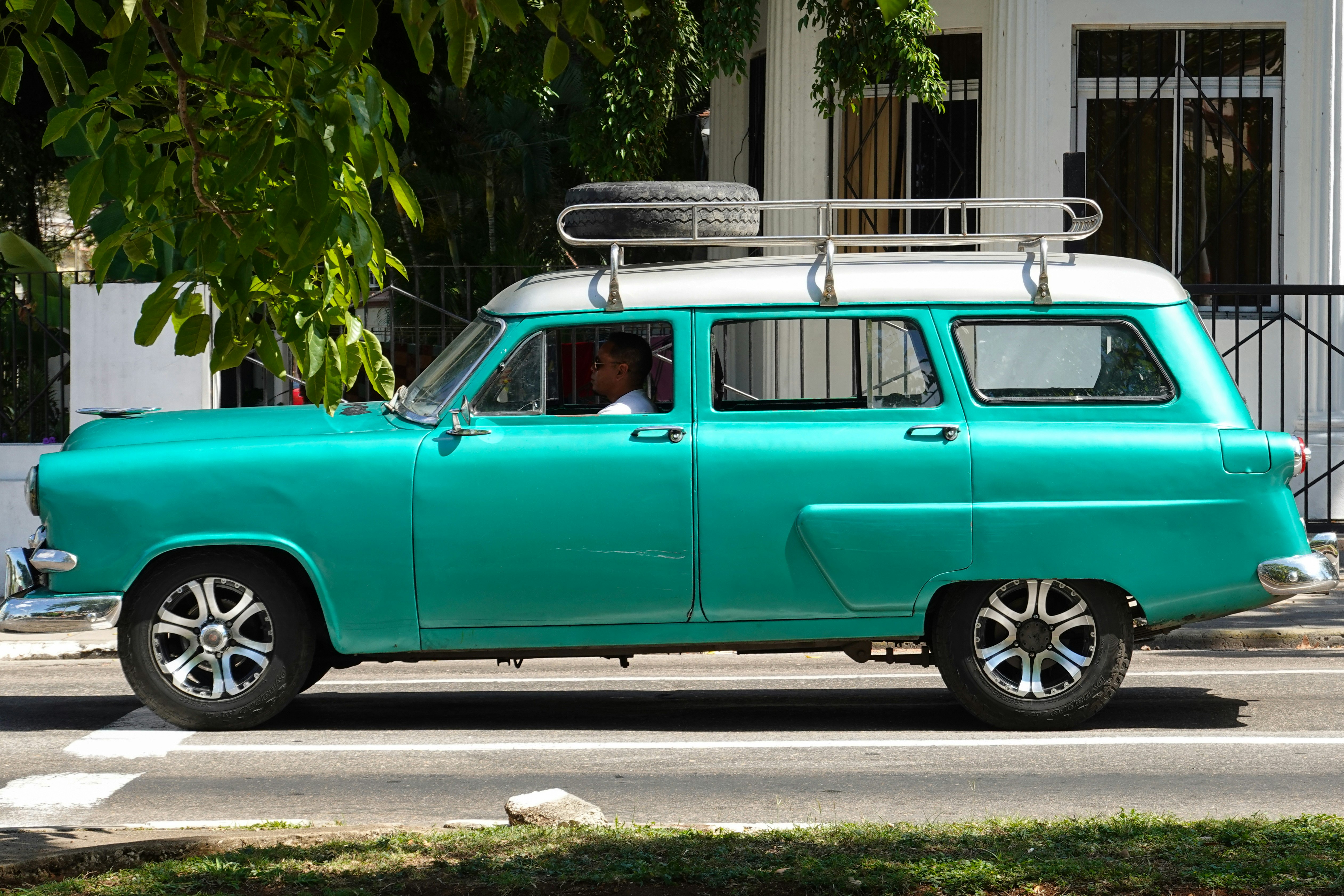 green station wagon parked on the side of the road during daytime